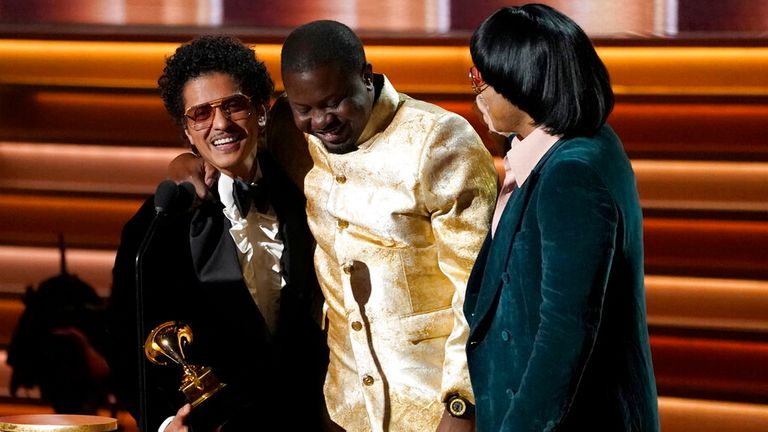 Dernst Emile II, centre, Bruno Mars, left, and Anderson Paak, right, of Silk Sonic accept the award for song of the year for Leave The Door Open at the Grammys in Las Vegas. Pic: AP Photo/Chris Pizzello