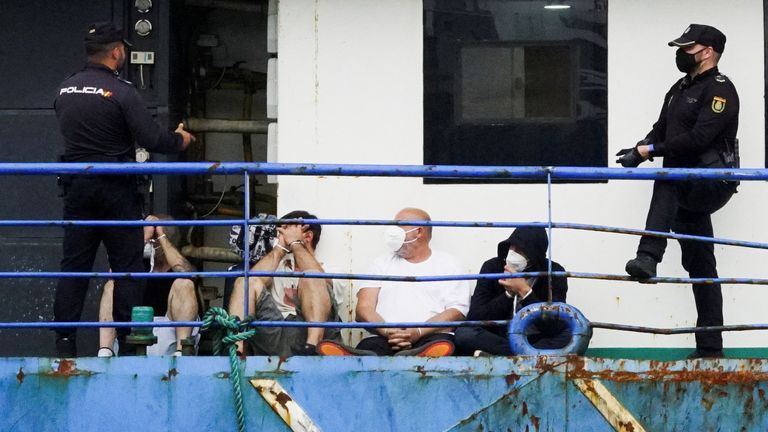 Police officers guard four detainees on the fishing boat "AKT-1" in the port of Las Palmas, in the island of Gran Canaria, Spain, April 16, 2022. REUTERS/Borja Suarez
