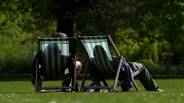 Les gens se détendent sur des transats au soleil du printemps à St James's Park, à Londres, en Grande-Bretagne, le 26 avril 2022. REUTERS/Toby Melville
