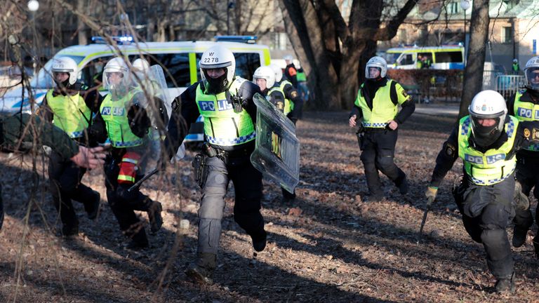 Police officers run during a protest ahead of a demonstration planned by Danish anti-Muslim politician Rasmus Paludan and his Stram Kurs party, which was to include a burning of the Muslim holy book, the Koran, in the park Sveaparken in Orebro, Sweden, April 15, 2022.Paul Wennerholm/ TT News Agency/via REUTERS ATTENTION EDITORS - THIS IMAGE WAS PROVIDED BY A THIRD PARTY. SWEDEN OUT. NO COMMERCIAL OR EDITORIAL SALES IN SWEDEN.