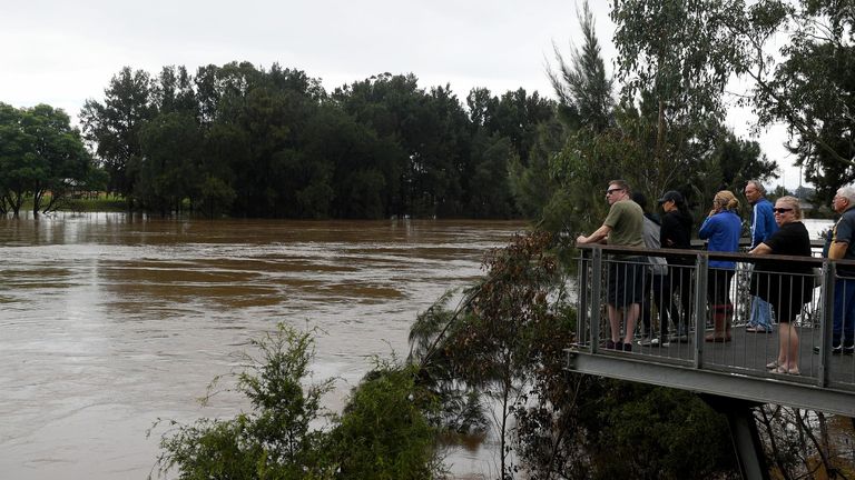 İnsanlar, Sidney, Yeni Güney Galler, Avustralya'da yükselen Hawkesbury nehrine bakıyor, 08 Nisan 2022. Sidney, Shoalhaven ve Wollongong bölgelerini sırılsıklam eden sağanak yağışlar, bazı bölgelerde sakinleri tahliye etmeye ve bazı okulları kapanmaya zorladı.