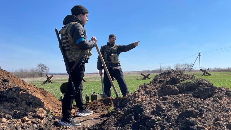 Ukrainian soldiers wrap blue tape around their right arm to identify themselves to each other