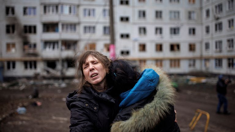 A woman reacts as she hugs another woman outside a heavily damaged apartment block, following an artillery attack, amid Russia&#39;s attack on Ukraine, in Kharkiv, Ukraine, April 13, 2022. REUTERS/Alkis Konstantinidis
