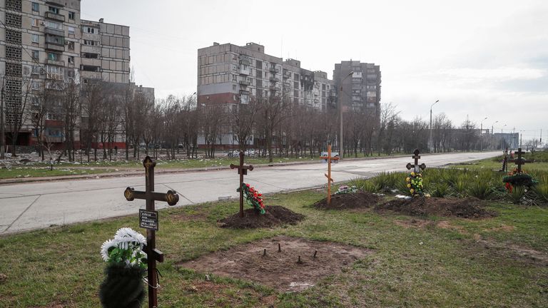 Graves of civilians killed during Ukraine-Russia conflict are seen next to apartment buildings in the southern port city of Mariupol, Ukraine April 10, 2022. REUTERS/Alexander Ermochenko