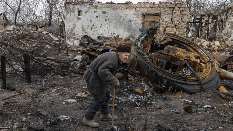 Oleksii Shcherbo, în vârstă de 98 de ani, trece pe lângă casa sa arsă și tancul rusesc distrus, în timp ce invazia Rusiei asupra Ucrainei continuă, în satul Sloboda, în afara Cernihiv, Ucraina, 5 aprilie 2022. REUTERS/Marko Djurica IMAGINI TPX ALE ZIUA