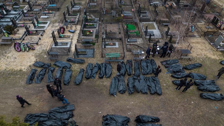 Police officers work during the identification process following the killing of civilians in Bucha, before taking the body to a morgue, on the outskirts of Kyiv, Ukraine, Wednesday, April 6, 2022. (AP Photo/ Rodrigo Abd)