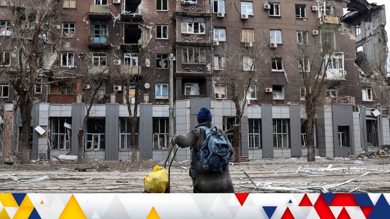 A local resident looks at a damaged during a heavy fighting apartment building near the Illich Iron & Steel Works Metallurgical Plant, the second largest metallurgical enterprise in Ukraine, in an area controlled by Russian-backed separatist forces in Mariupol, Ukraine, Saturday, April 16, 2022. Mariupol, a strategic port on the Sea of Azov, has been besieged by Russian troops and forces from self-proclaimed separatist areas in eastern Ukraine for more than six weeks. (AP Photo/Alexei Alexandrov)