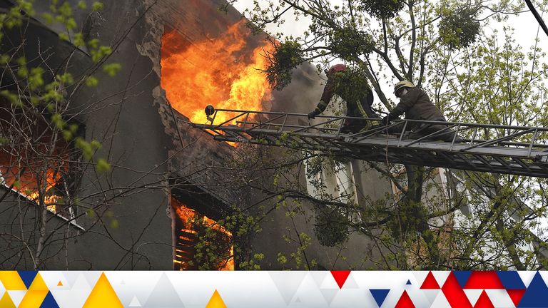 Firefighters work to extinguish a fire at an apartment building after a Russian attack in Kharkiv. Pic: AP