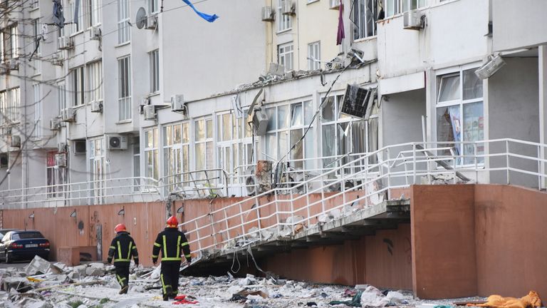 Firefighters walk past an apartment building damaged by Russian shelling in Odesa, Ukraine. Pic: AP