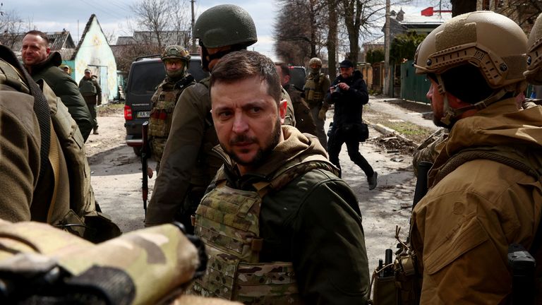 Ukrayna Devlet Başkanı Volodymyr Zelenskyy, Rusya'nın Ukrayna'yı işgali devam ederken, Ukrayna'nın Kiev kentinin dışındaki Bucha'da 4 Nisan 2022'de Ukraynalı askerler tarafından çevrelenirken izliyor. REUTERS/Marko Djurica