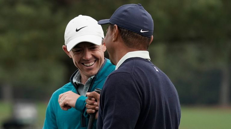Tiger Woods is greeted by Rory McIlroy during a practice round for the Masters 