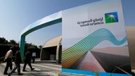 FILE PHOTO: The logo of Aramco is seen as security personnel walk before the start of a press conference by Aramco at the Plaza Conference Center in Dhahran, Saudi Arabia November 3, 2019