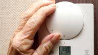 A generic stock photo of an elderly lady adjusting her thermostat on at home in Liverpool.
