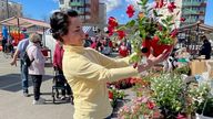 Maria Tania-Parviainen, one of around 80,000 Russians living in Finland, looks at flowers at a local market in Lappeenranta, Finland, near the Russian border; 14 May 2022
