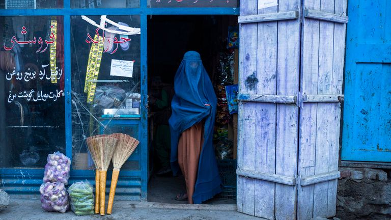 An Afghan woman wearing a burka exits a small shop in Kabul, Afghanistan, Sunday, Dec. 5, 2021. Women&#39;s rights activists in the Afghan capital of Kabul insisted Sunday they would continue fighting for their right to education, employment and participation in Afghan political and social life, and said a recent Taliban decree banning forced marriage was not enough to address the issue of women&#39;s rights. (AP Photo/Petros Giannakouris)                