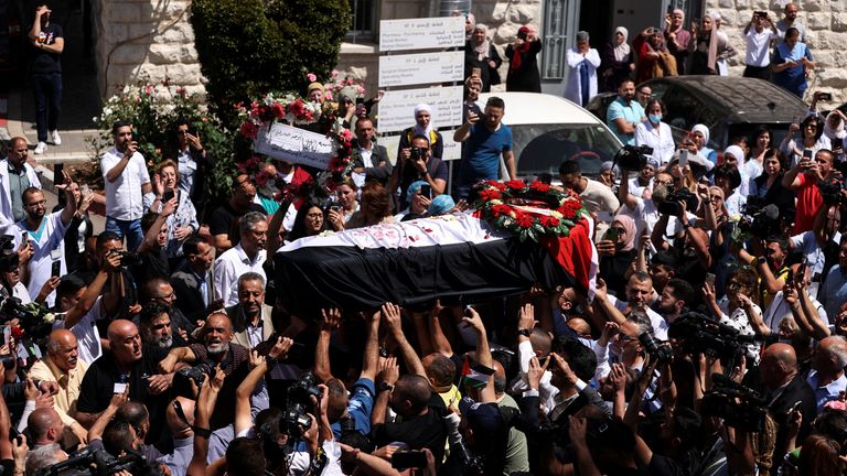 Family and friends of Al Jazeera reporter Shireen Abu Akleh, who was killed during an Israeli raid in Jenin in the occupied West Bank, carry her body as she arrives in Jerusalem, May 12, 2022. REUTERS/Ammar Awad
