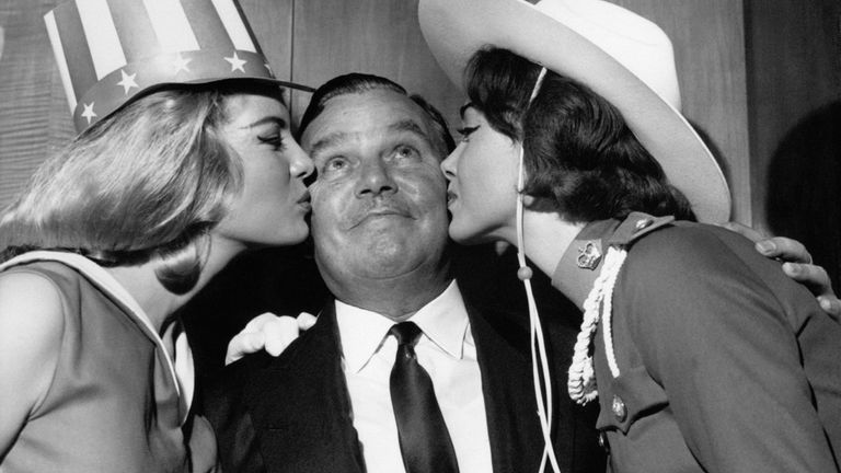 PA NEWS PHOTO 6/11/62 BILLY BUTLIN KING OF THE HOLIDAY CAMP "BUTLINS" RECEIVING A DUAL KISS FROM MISS AMERICA AND MISS CANADA AS THEY COMPETE FOR THE MISS WORLD TITLE. * 11/4/01: The great British holiday resort Butlins celebrates its 65th birthday. Butlins, that has launched the careers of celebrities past and present, first opened its doors to holidaymakers in 1936 in Skegness, Lincolnshire. Their famous Redcoats have kept the work-weary entertained at resorts across the country. 