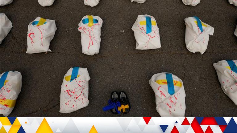 Items sprayed in red paint symbolizing, according to organizers, the children killed during the Russian invasion in Ukraine are placed on the tarmac during a protest against Russia&#39;s war in Ukraine, in front of the Russian embassy in Bucharest, Romania, Saturday, April 16, 2022. (AP Photo/Andreea Alexandru)