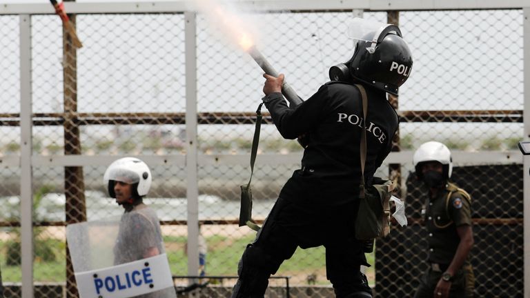 A Riot police officer fires tear gas to chase back the supporters of Sri Lanka&#39;s ruling party during a clash with anti-government demonstrators, amid the country&#39;s economic crisis, in Colombo, Sri Lanka, May 9, 2022. REUTERS/Dinuka Liyanawatte
