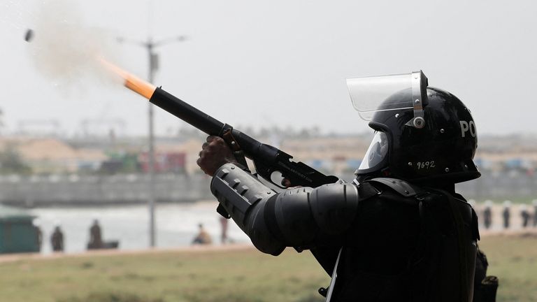 A riot police officer fires tear gas to chase back the supporters of Sri Lanka&#39;s ruling party during a clash with anti-government demonstrators, amid the country&#39;s economic crisis, in Colombo, Sri Lanka, May 9, 2022. REUTERS/Dinuka Liyanawatte
