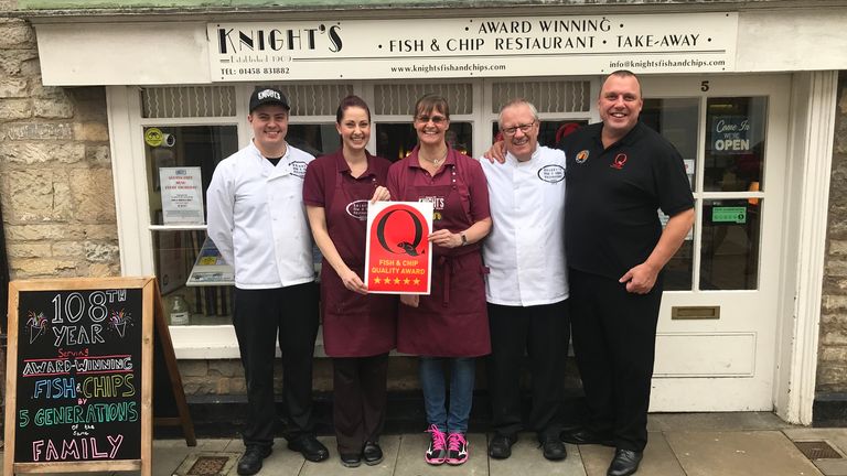 George Knight and his family outside their fish and chip shop in Glastonbury. It&#39;s thought to be one of the oldest family-run chippies in the UK