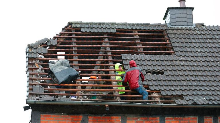 People inspect the damage to a roof in Lippstadt. Pic: AP