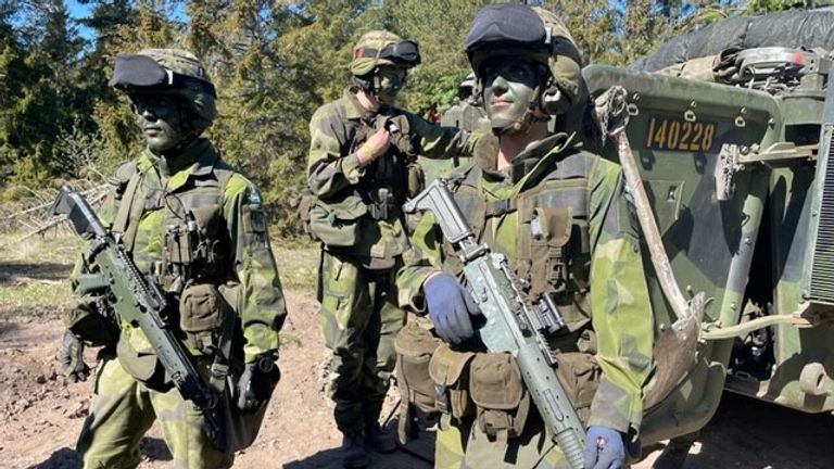 Des soldats conscrits se rassemblent autour d'un véhicule de combat d'infanterie (IFV) lors d'un exercice à Gotland