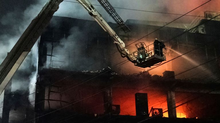 Fire officials try to douse a fire in a four storied building, in New Delhi, India, Friday, May 13, 2022. A massive fire erupted in a four-storied building in the Indian capital on Friday, killing at least 19 people and leaving several injured, the fire control room said. Dozens of people have been rescued from the commercial building, mainly shops, in the Mundka area in the western part of New Delhi. (AP Photo/Dinesh Joshi)


