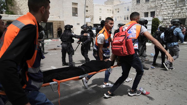 Palestinian medics evacuate a mourner wounded during clashes when Israeli police confronted people gathered when Ms Abu Akleh&#39;s body was transferred to her funeral. Pic: AP