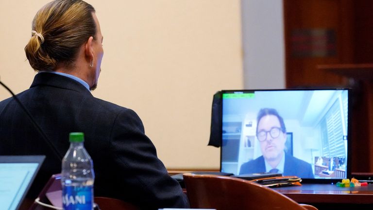 Jack Whigham, talent manager for Johnny Depp, is seen on a monitor as he testifies remotely at Fairfax County Circuit Court during a defamation case against her by Depp, her ex-husband, in Fairfax, Virginia, U.S., May 2, 2022. Steve Helber/Pool via REUTERS
