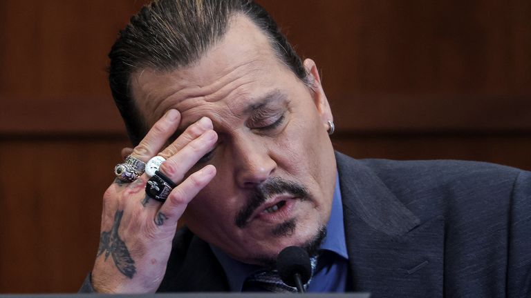 Actor Johnny Depp reacts as he testifies in the courtroom during his defamation trial against his ex-wife Amber Heard, at the Fairfax County Circuit Courthouse in Fairfax, Virginia, U.S., May 25, 2022. REUTERS/Evelyn Hockstein/Pool
