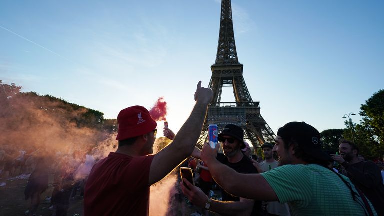 Paris Fransa'daki Stade de France'da Liverpool FC ile Real Madrid arasında oynanacak Cumartesi günü UEFA Şampiyonlar Ligi Finali öncesinde Paris'teki Eyfel Kulesi yakınlarındaki futbolseverler.  Resim tarihi: 27 Mayıs 2022 Cuma.