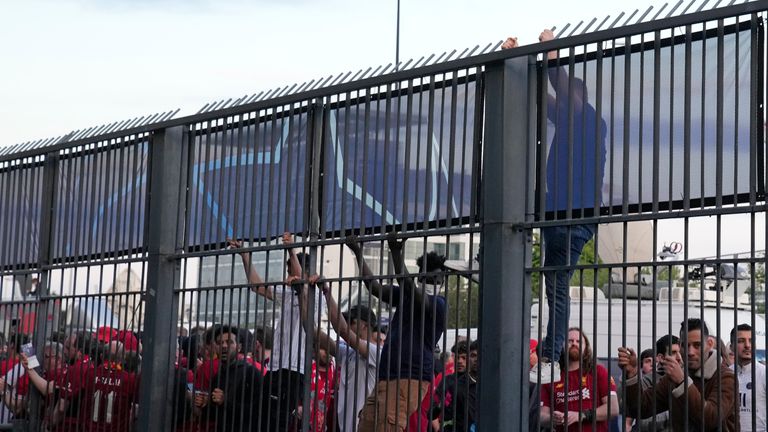 Fans climb on the fence in front of the Stade de France as some Liverpool supporters were kept outside until half time