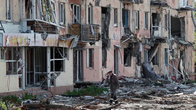 A local resident walks near a building heavily damaged during Ukraine-Russia conflict in the southern port city of Mariupol, Ukraine May 20, 2022. REUTERS/Alexander Ermochenko