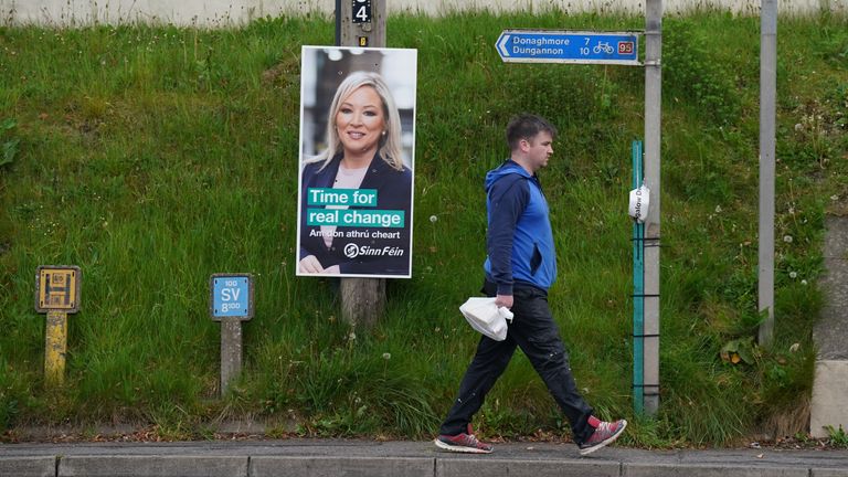 A man walks past an election poster for Sinn Fein showing Michelle O&#39;Neill in Stewartstown, Co Tyrone, as voters cast their vote in the 2022 NI Assembly election. Picture date: Thursday May 5, 2022.
