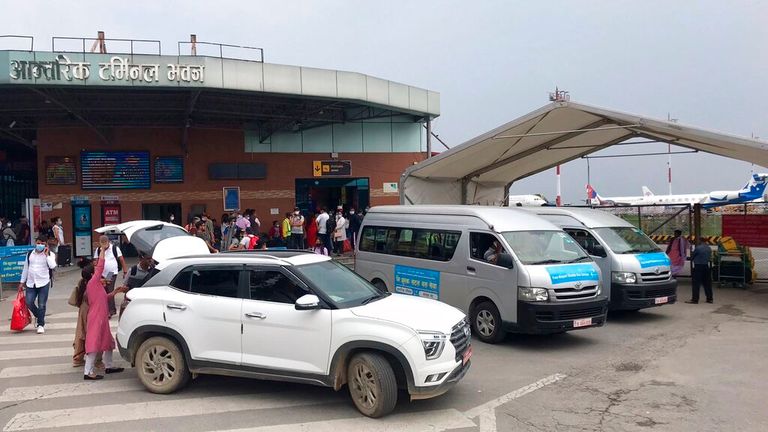 People walk outside the Tribhuvan International Airport in Kathmandu, Nepal, following the news