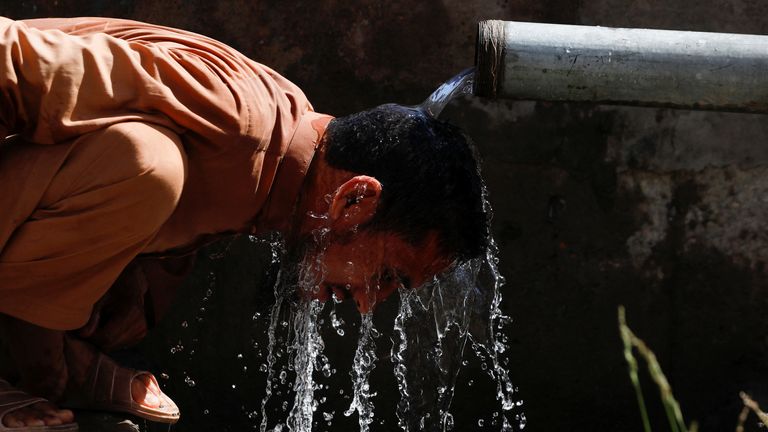 Pakistan'ın Peşaver kentinde sıcak bir günde bir adam kendini serinletiyor.