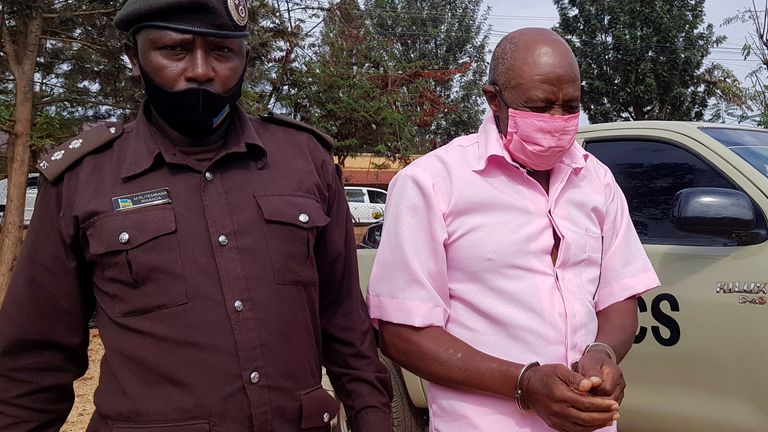 Paul Rusesabagina, portrayed as a hero in a Hollywood movie about Rwanda&#39;s 1994 genocide, is escorted in handcuffs into a courtroom, in Kigali