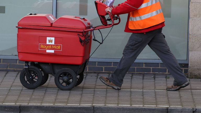 File photo dated 25/01/18 of a postman delivering letters in Woking, Surrey, as Royal Mail has said it will need to hike prices and slash costs to offset soaring inflation amid an &#34;uncertain&#34; outlook for the economy as it posted a rise in annual earnings.
