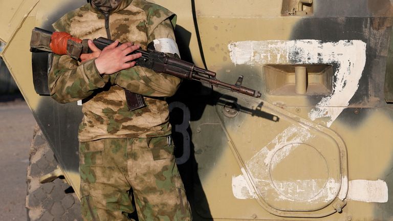 Rus yanlısı birliklerin bir hizmet üyesi, sembolü olan bir savaş aracının yanında nöbet tutuyor "Z" 16 Mayıs 2022'de Ukrayna'nın Mariupol kentindeki Ukrayna-Rusya çatışması sırasında kuşatma altındaki Azovstal çelik fabrikasından yaralı Ukraynalı askerlerin tahliyesi beklenmeden önce kendi tarafında görülüyor. REUTERS/Alexander Ermochenko TPX GÜNÜN GÖRÜNTÜLERİ