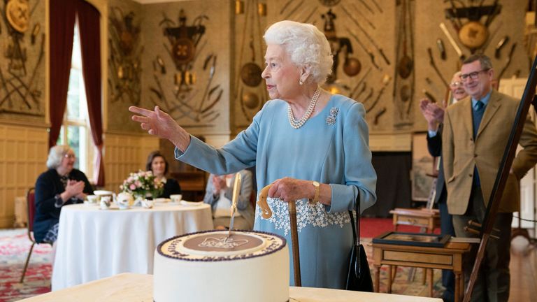 Britain&#39;s Queen Elizabeth II cuts a cake to celebrate the start of the Platinum Jubilee, at Sandringham House, her Norfolk residence, in Sandringham, England, Saturday, Feb. 5, 2022. The Queen has hosted a reception for members of the local community and volunteer groups at Sandringham House on the eve of Accession Day, the seventieth anniversary of her reign. (Joe Giddens/Pool Photo via AP)