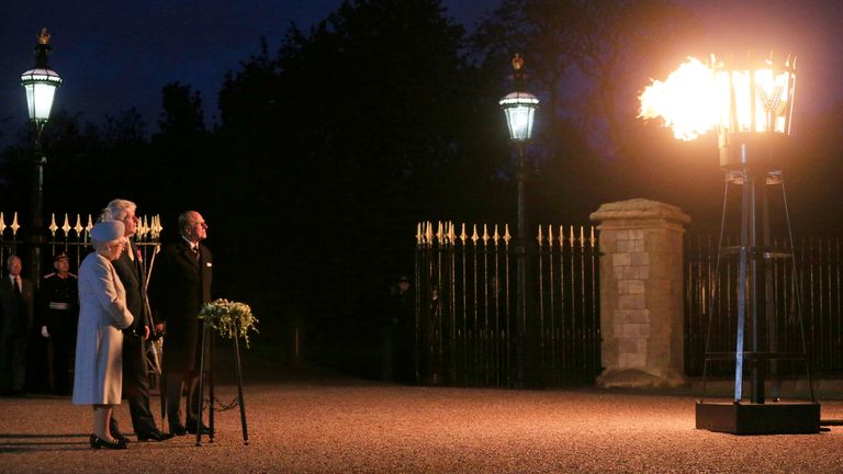 Queen Elizabeth II accompanied by the Duke of Edinburgh (right) lights the first of over 200 beacons to commemorate the 70th anniversary of VE Day at Windsor Castle.