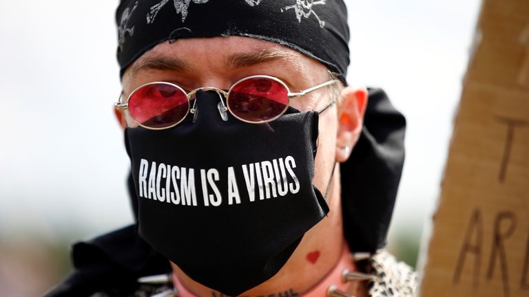 A demonstrator wears a face mask with a message against racism as he attends a Black Lives Matter protest at Hyde Park, following the death of George Floyd in Minneapolis police custody, in London, Britain, June 20, 2020. REUTERS/Henry Nicholls