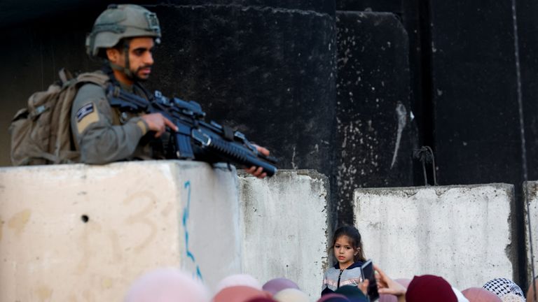 A soldier patrols as Palestinians make their way to attend the last Friday prayers of Ramadan in Jerusalem&#39;s Al-Aqsa mosque