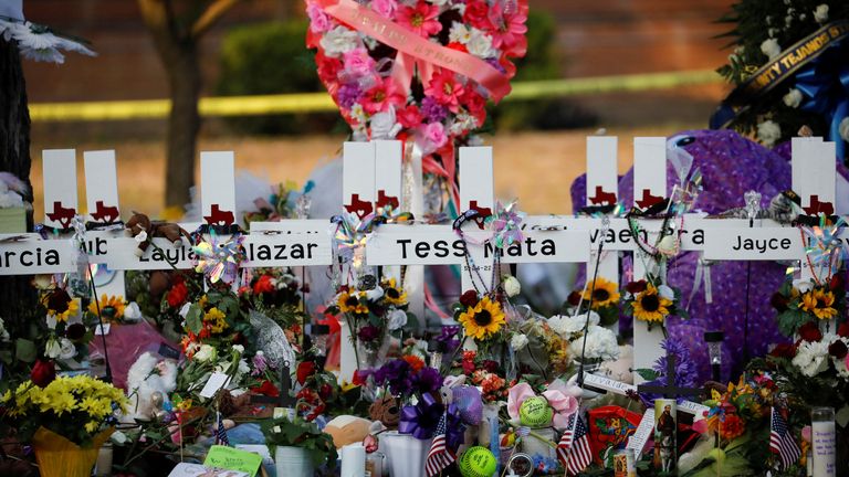 28 Mayıs 2022 ABD, Uvalde, Teksas'ta 19 çocuk ve iki öğretmenin silahlı bir kişi tarafından öldürülmesinin ardından, Robb İlkokulu dışındaki bir anma töreninde okulda vurulan kurbanların isimlerinin yazılı olduğu haçların önüne çiçekler, mumlar ve resimler bırakıldı. REUTERS/Marco Bello