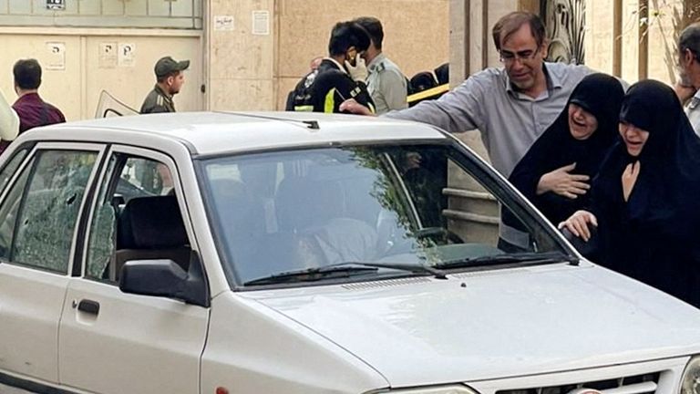 Family members of Colonel Sayad Khodai weep over his body in his car after he was reportedly shot by two assailants in Tehran