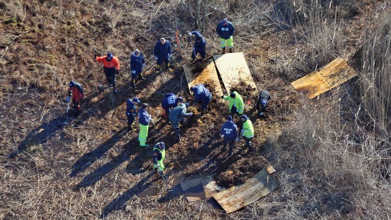 In this Dec. 8, 2011 photo, investigators search for Shannan Gilbert's body in a marsh area just east of Oak Beach, N.Y. After a yearlong search, police on New York's Long Island said Tuesday they believe they have discovered the skeletal remains of a New Jersey prostitute whose disappearance sparked an investigation into a possible serial killing spree. (AP Photo/Kevin P. Coughlin)