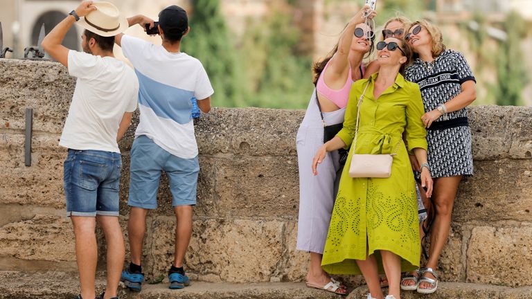 I turisti scattano foto durante un episodio di temperature eccezionalmente elevate in quel periodo dell'anno a Ronda, in Spagna, il 20 maggio 2022. REUTERS/John Nazca