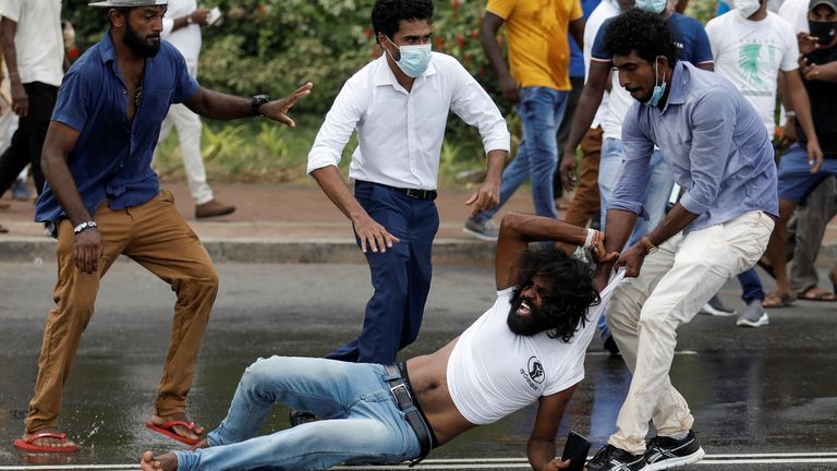 Supporter of Sri Lanka&#39;s ruling party tugs a member of anti-government demonstrator by his shirt during a clash between the two groups, amid the country&#39;s economic crisis in Colombo, Sri Lanka, April May 9, 2022. REUTERS/Dinuka Liyanawatte
