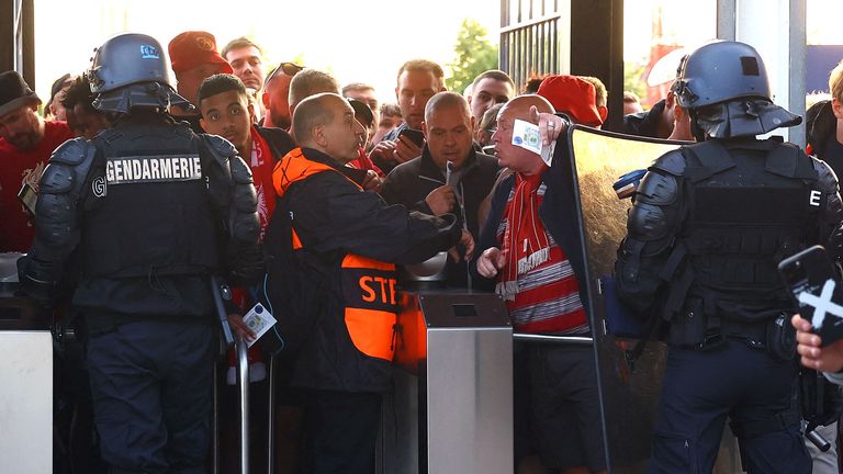 Les supporters de Liverpool montrent aux stewards leurs billets aux tourniquets 